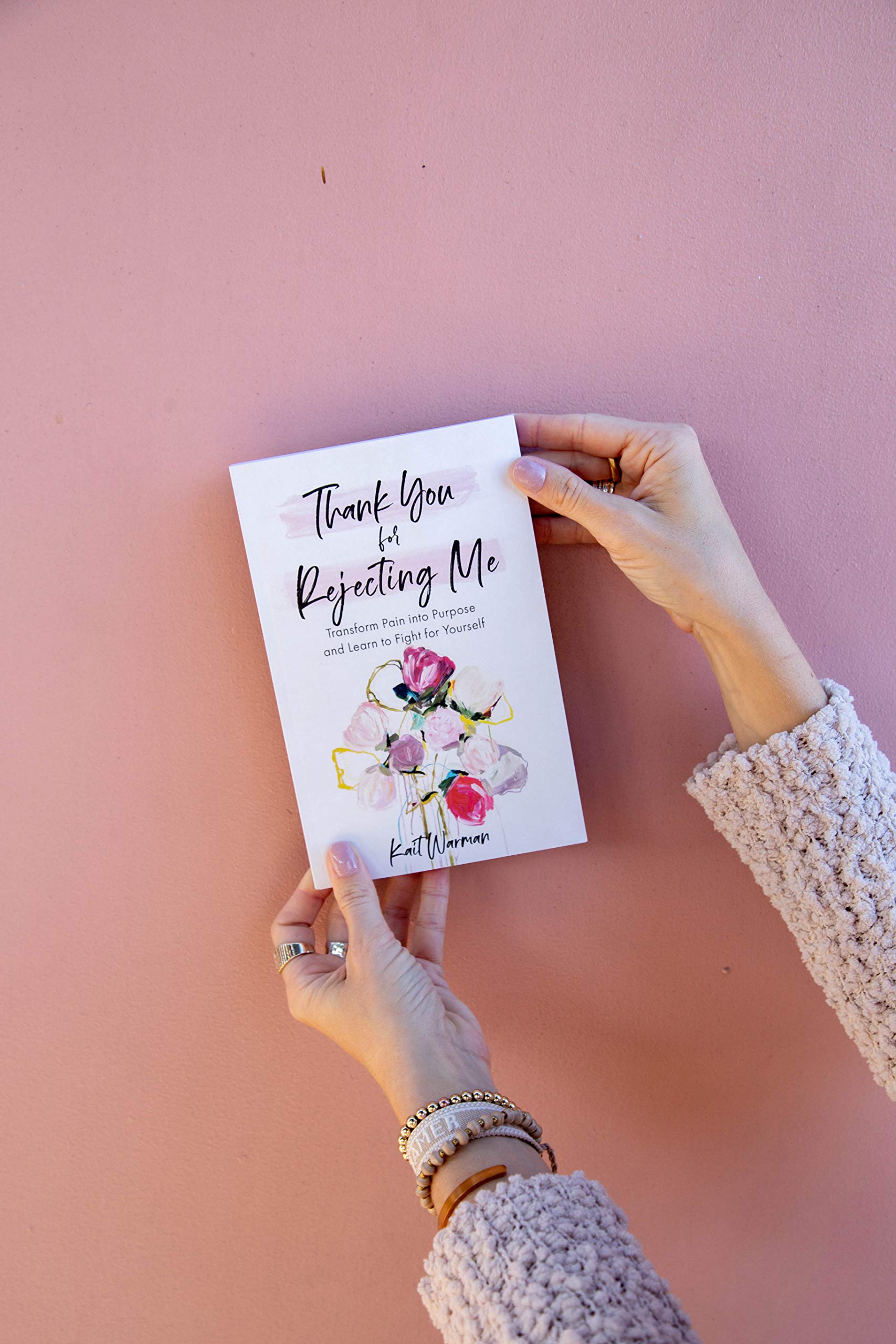 Woman's hands holding "Thank You for Rejecting Me" book