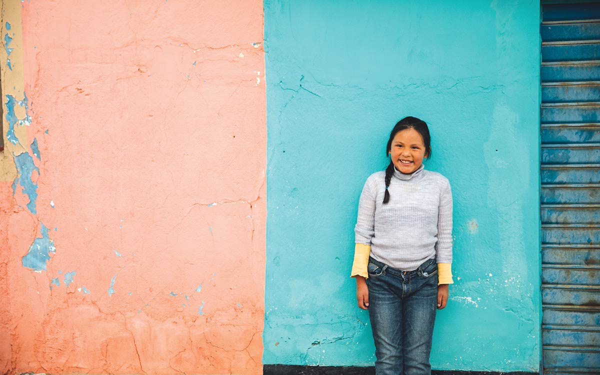 Child standing in front of a colorful wall