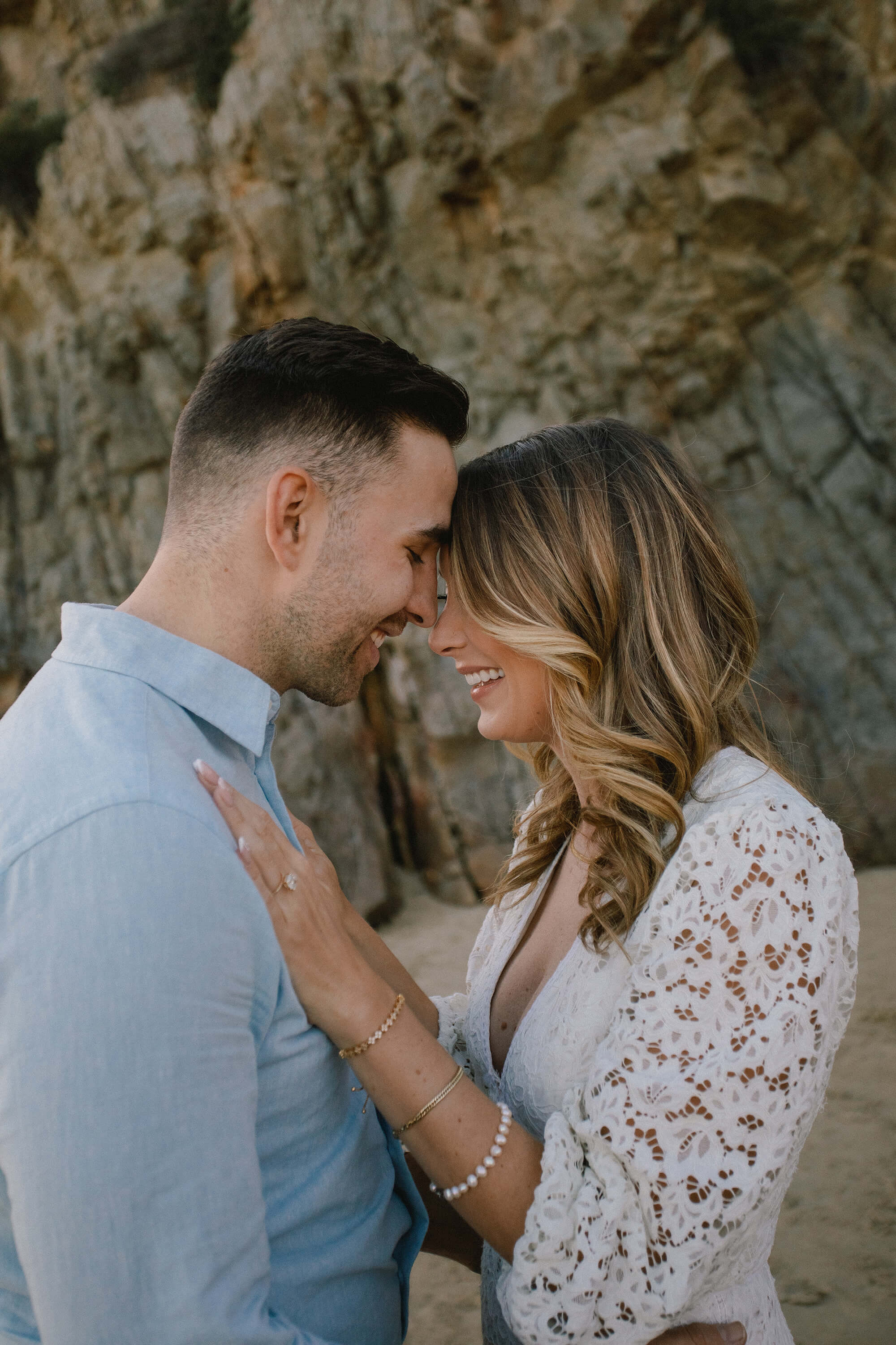 JJ and Kait standing head to head on the beach.