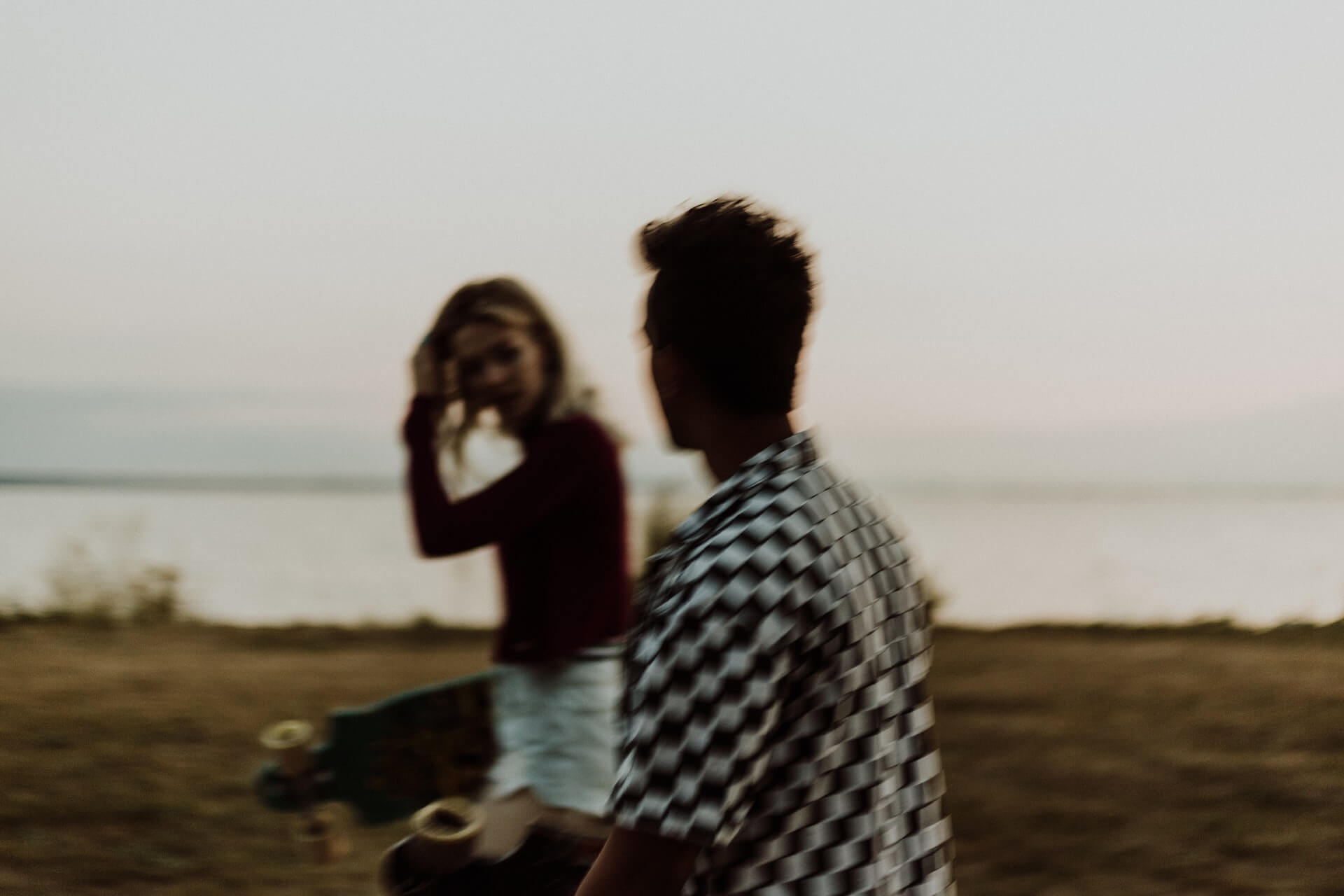 Lady and guy walking with skateboards talking