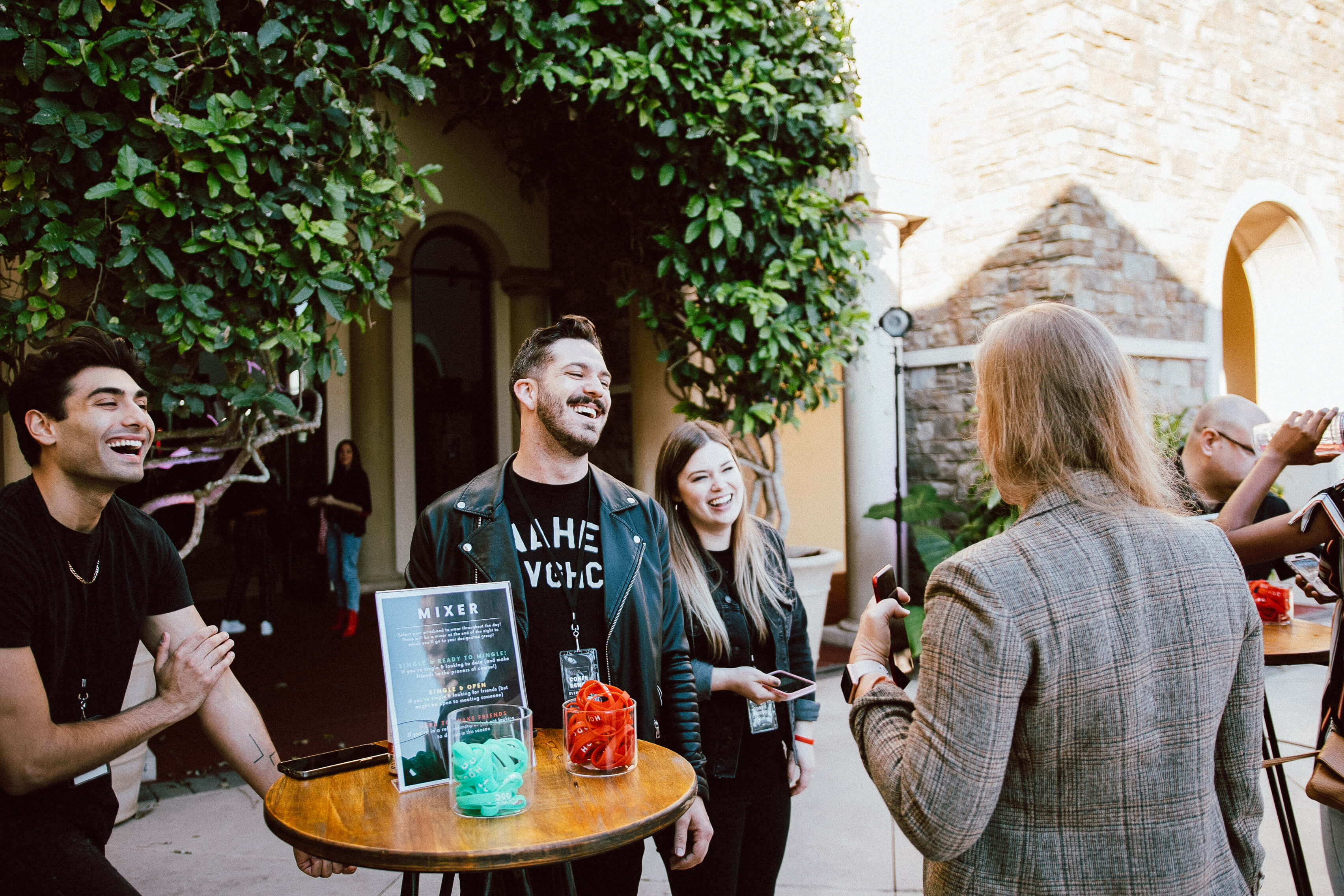 Group of people standing around a table laughing and chatting