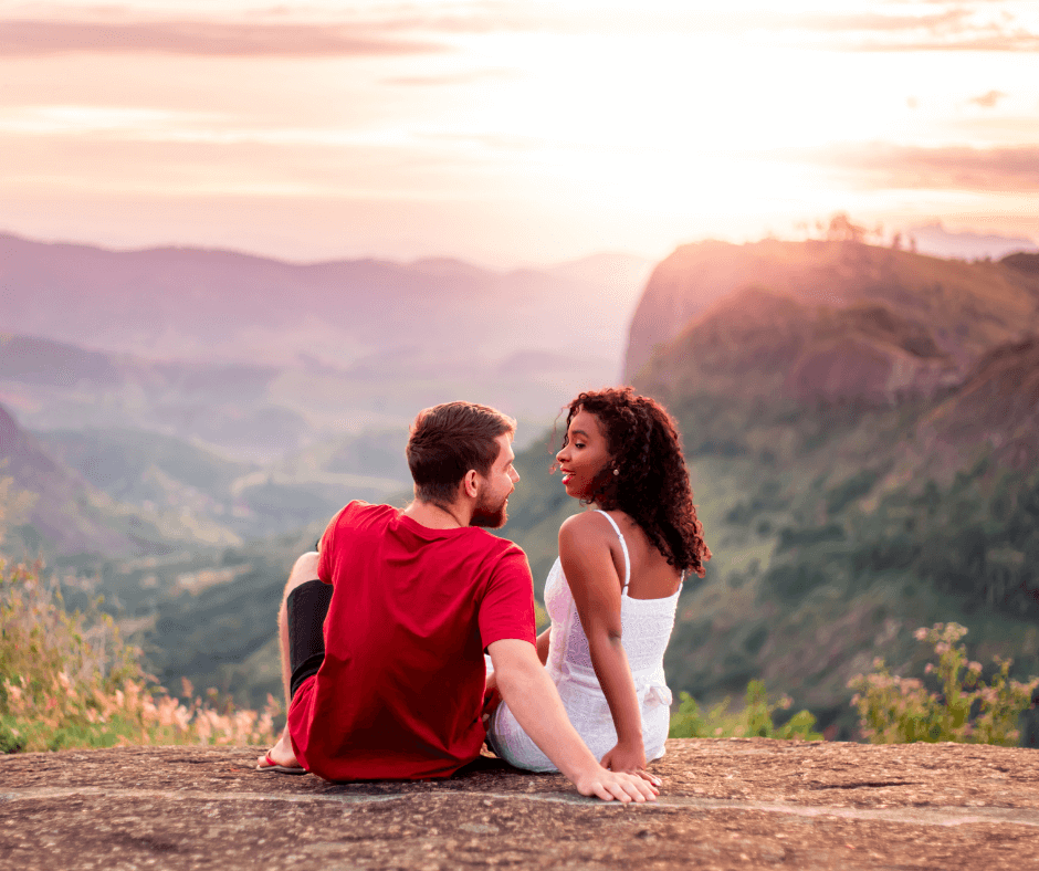 Couple sitting on the edge of a mountain